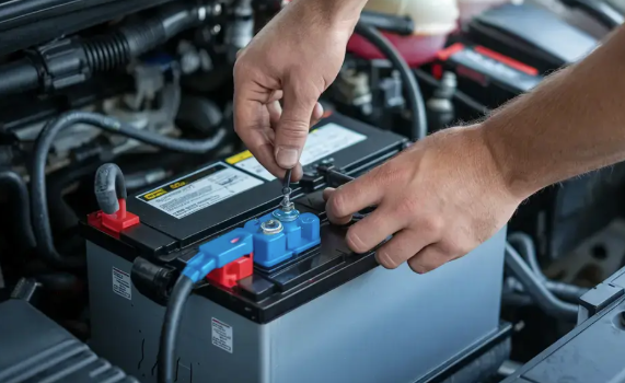 Technician testing a car battery with a battery tester at McCarthy Jeep Ram Chrysler Dodge service in Lee's Summit, MO
