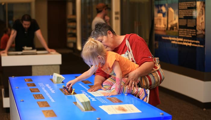 Family enjoying hands-on exhibit at Kansas City Money Museum